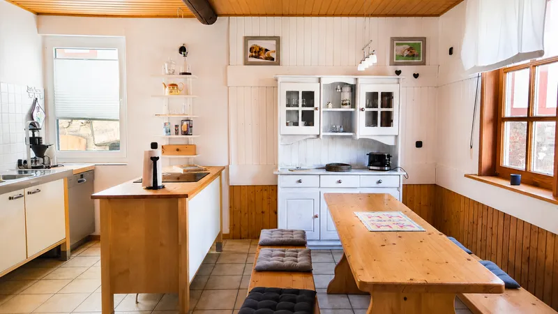 Gemeinschaftsküche mit Herd, Backofen und großem Holztisch