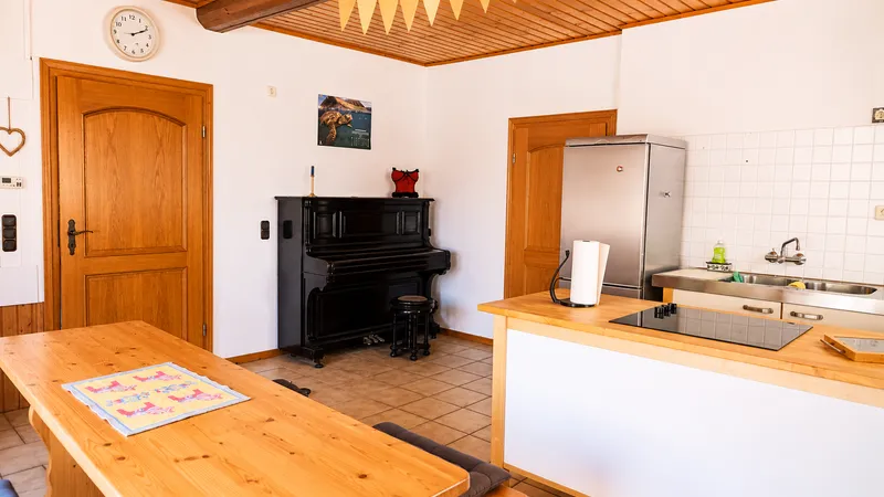 Küche mit Arbeitsplatte, langer Tafel und Sitzbänken