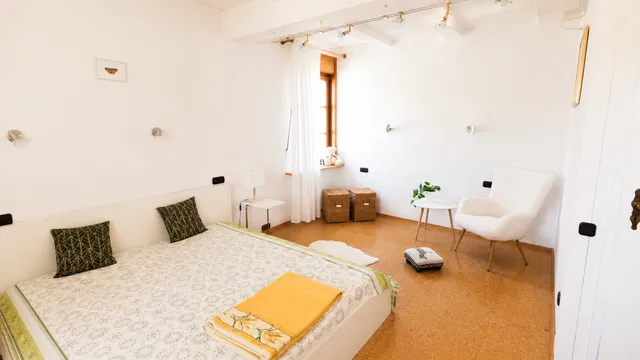 Helles Gästezimmer mit Holzbalken und weißen Wänden